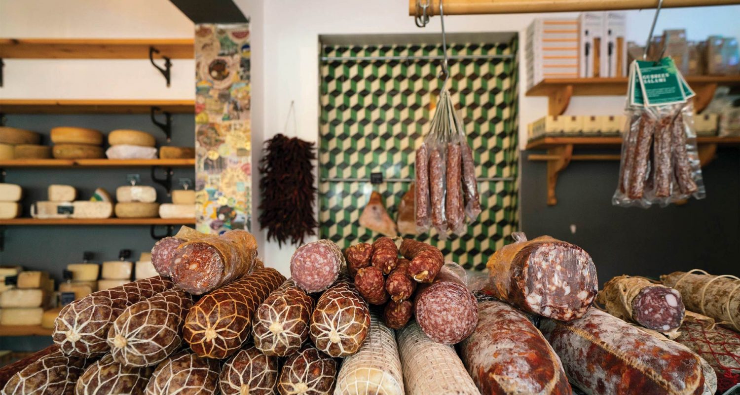 Commercial photograph of deli counter, aesthetic display of salamis and meat