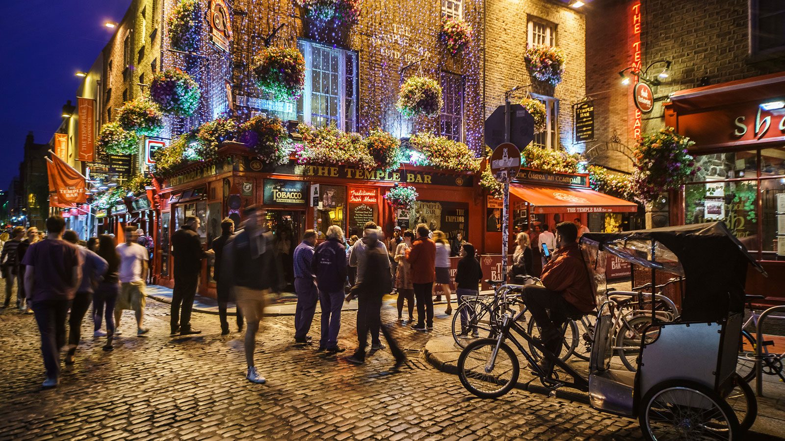 Crowd of people at night outside Temple Bar in Dublin, Ireland